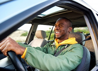 Man smiles while driving