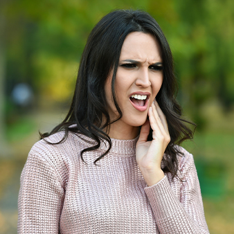 Woman in pain holding cheek