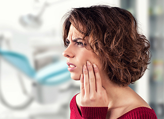 Woman holding cheek in pain