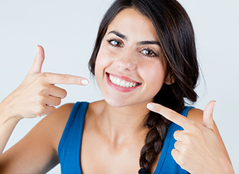 Woman pointing to flawless smile