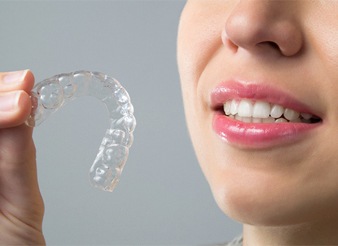 A woman holding on to an aligner