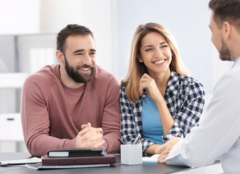 A couple discussing with a dental professional