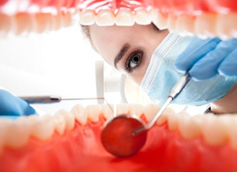 A dentist examining a patient’s mouth.