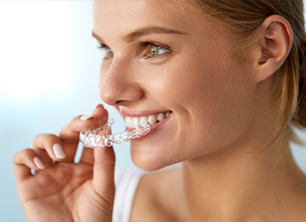 Woman placing Invisalign tray