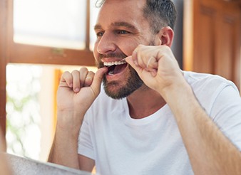 Man flossing his teeth