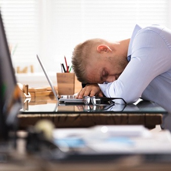 A man sleeping at his desk.