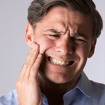 Man in pain holding jaw