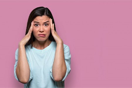 Woman looking stressed and holding her head.